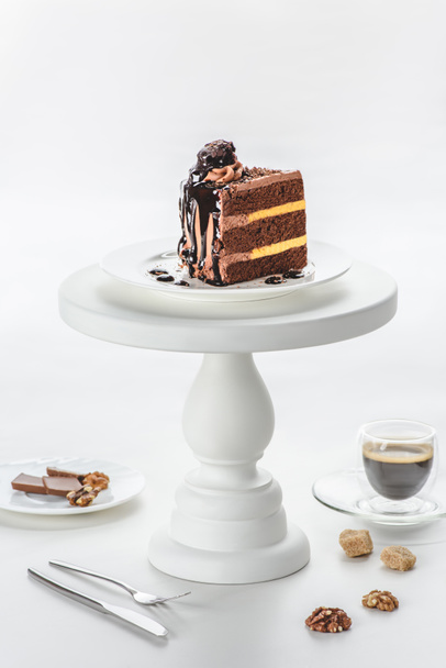 piece of chocolate cake on white cake stand - Foto, afbeelding