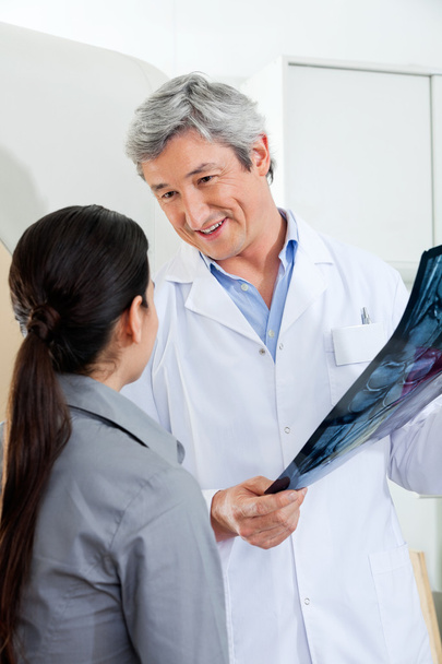 Radiologiste regardant le patient tout en tenant une radiographie
 - Photo, image