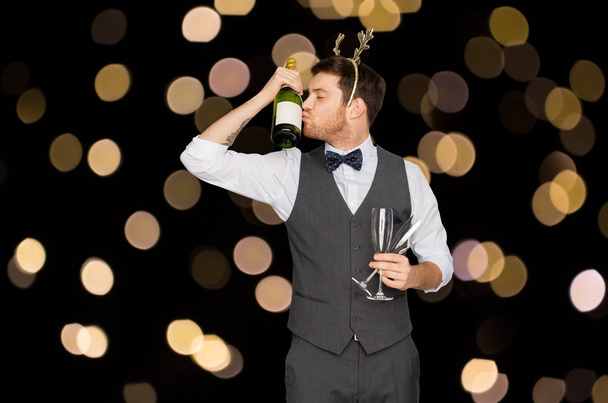 man kissing bottle of champagne at christmas party - Φωτογραφία, εικόνα