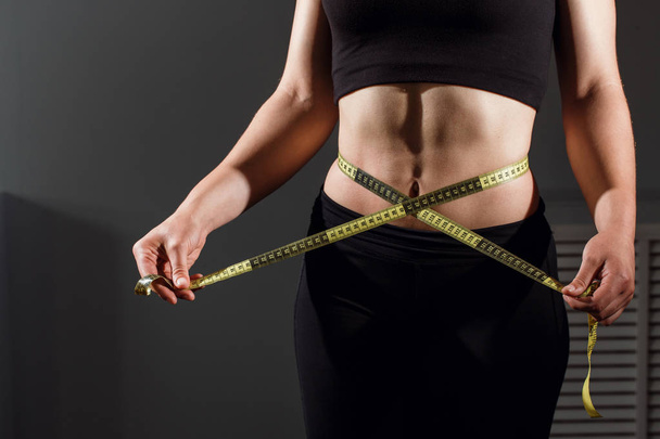 close up of slimming woman body with measure tape - Φωτογραφία, εικόνα