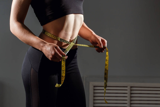 Woman measuring her waistline. Closeup female with perfect slim body and torso - Foto, imagen