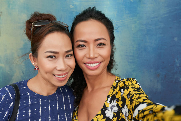 Duas belas mulheres vietnamitas tirando selfie juntas
 - Foto, Imagem