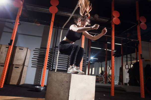 Fit young woman box jumping at a cross fit gym - Fotoğraf, Görsel