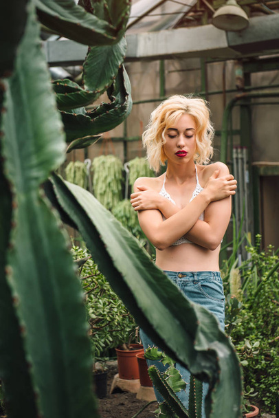 Sensual female fashion model posing at greenhouse - Фото, зображення