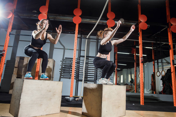 Fitness woman jumping on box training at the gym, cross fit exercise - Foto, Imagem