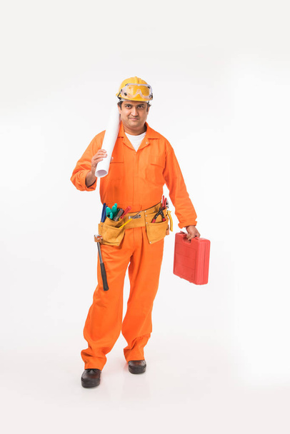 Indian electrician engineer in action with wire cutter, drilling machine etc, standing isolated over white background - Foto, imagen