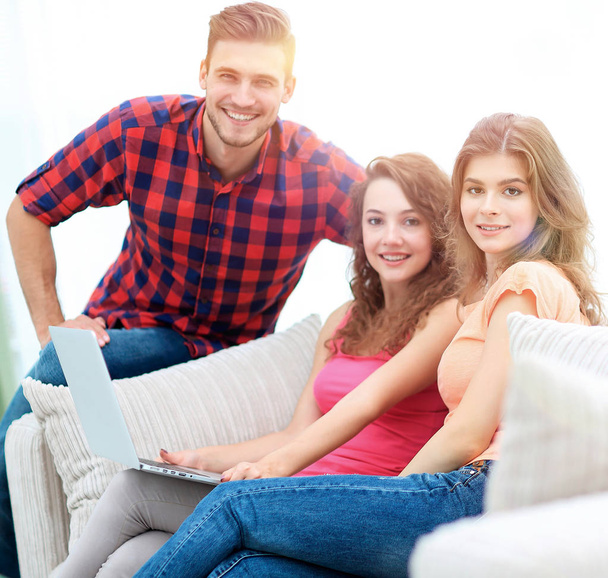 group of young people sitting on the couch in the living room. - 写真・画像