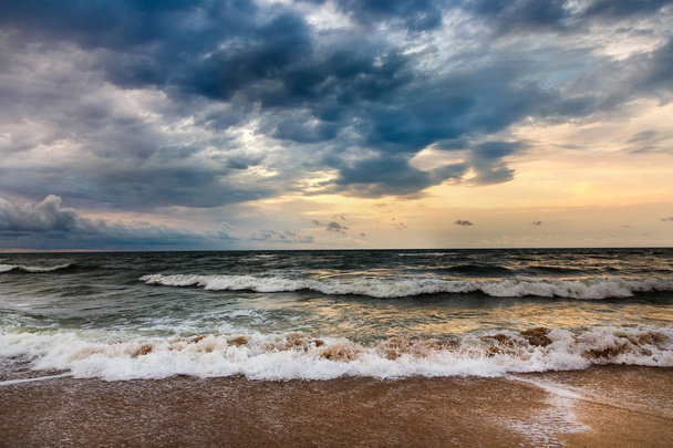 Dramaattinen taivas aamun merimaisemassa. Myrsky hiekkarannalla
. - Valokuva, kuva