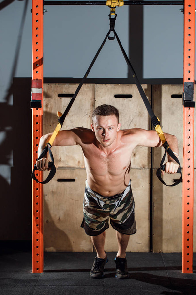 Cross fit fitness TRX push ups man workout at gym - Foto, afbeelding