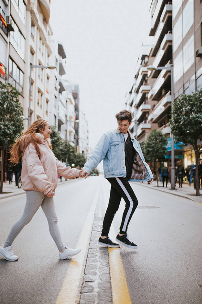 Пара закоханих, що йдуть по вулиці. Молоді люди йдуть по вулиці
 - Фото, зображення