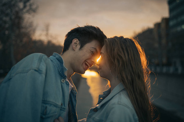 Amantes jóvenes besándose en una hermosa puesta de sol. Día de San Valentín
 - Foto, Imagen