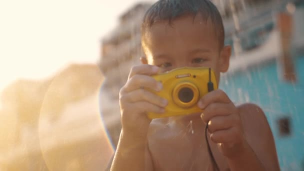 Niño con cámara impermeable bajo ducha de playa
 - Imágenes, Vídeo
