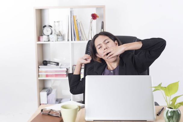 ásia mulher de negócios sentado no o mesa computador no escritório com sonolento
. - Foto, Imagem