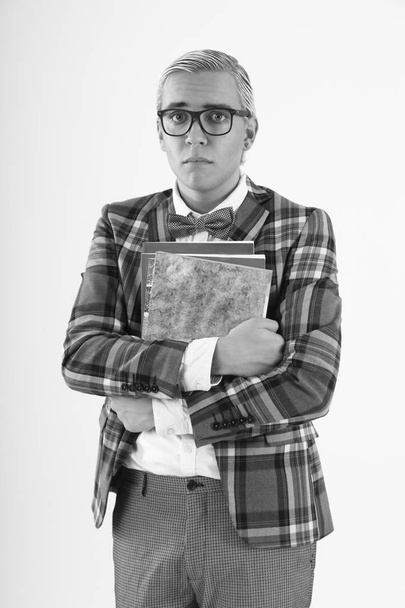 triste nerd uomo in piedi in giacca a scacchi e occhiali con quaderni su sfondo bianco
 - Foto, immagini