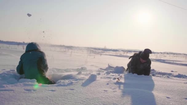 冬の新鮮な空気で遊んでいる子供たちは、雪玉を投げます。アクティブなアウトドア スポーツ - 映像、動画