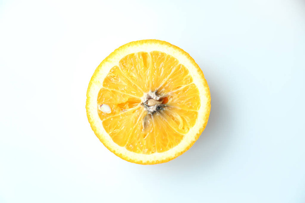 Rebanada podrida mohosa naranja sobre fondo blanco, vista superior
 - Foto, imagen