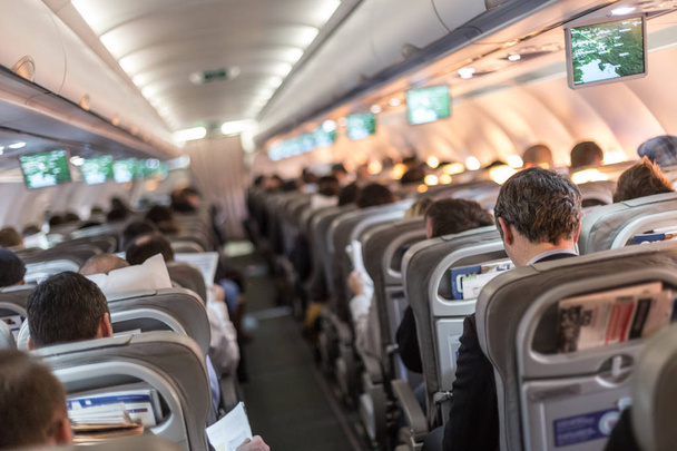 Intérieur de l'avion avec des passagers sur les sièges en attente de taik off
. - Photo, image