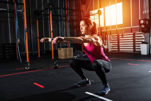 Ustalić athletic dziewczyna squat ćwiczeń na siłowni - Zdjęcie, obraz