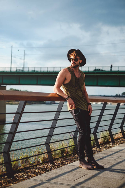 Hipster uomo in piedi vicino al fiume e godersi il sole
 - Foto, immagini