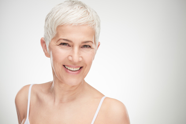 Portrait of beautiful senior woman in front of white background. - Foto, afbeelding