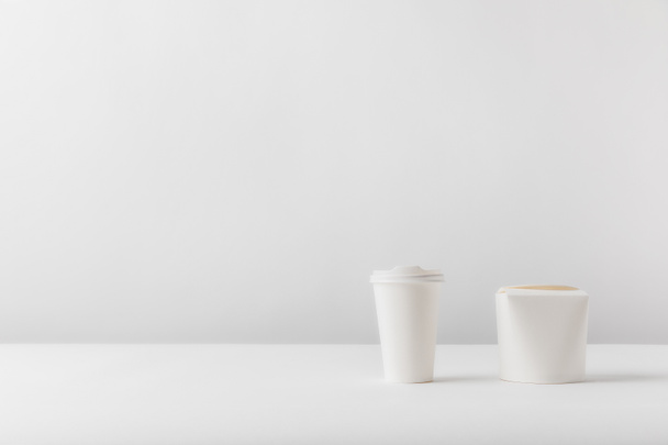 tasse à café jetable et boîte à nouilles sur surface blanche
 - Photo, image
