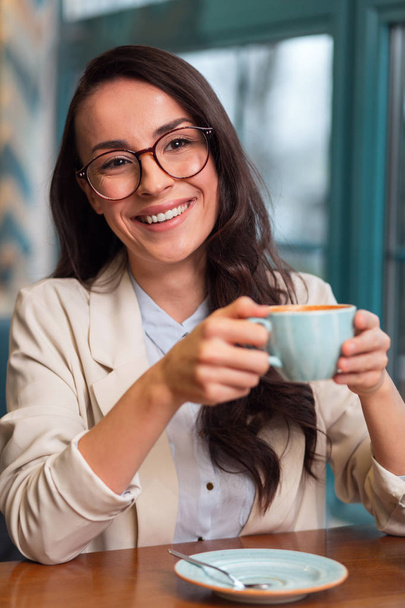 Pensive jolly woman deriving pleasure from coffee - Foto, immagini