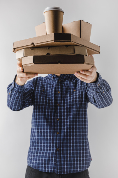 Курьер держит коробки пиццы и лапши коробки изолированы на белом
 - Фото, изображение