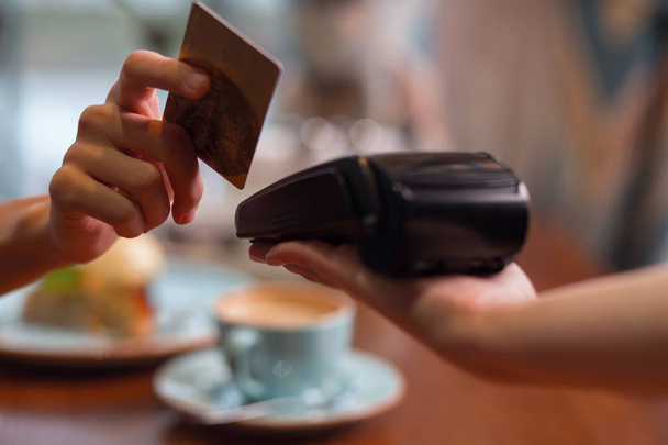 Female hand with credit card swipe through terminal - Fotoğraf, Görsel