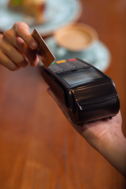 Human hand holding plastic card in payment machine - Fotoğraf, Görsel