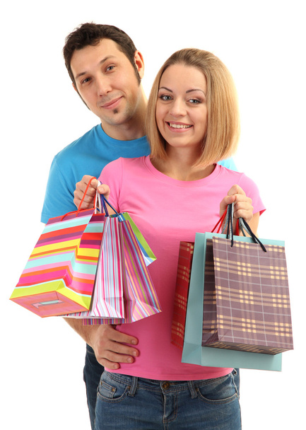 Young couple shopping and holding many shopping bags isolated on white - Foto, afbeelding