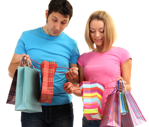 Young couple shopping and holding many shopping bags isolated on white - Foto, Imagem