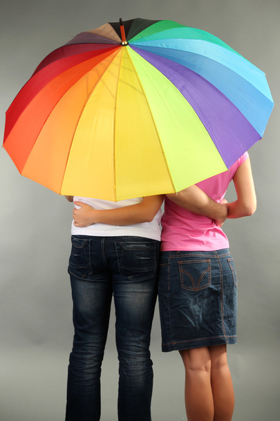 Loving couple with umbrella on grey background - Foto, Imagem