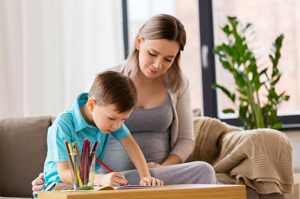 pregnant mother and son with workbook at home - Φωτογραφία, εικόνα