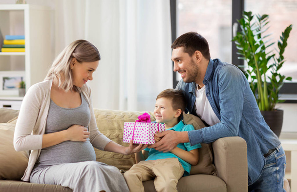family giving present to pregnant mother at home - Fotoğraf, Görsel