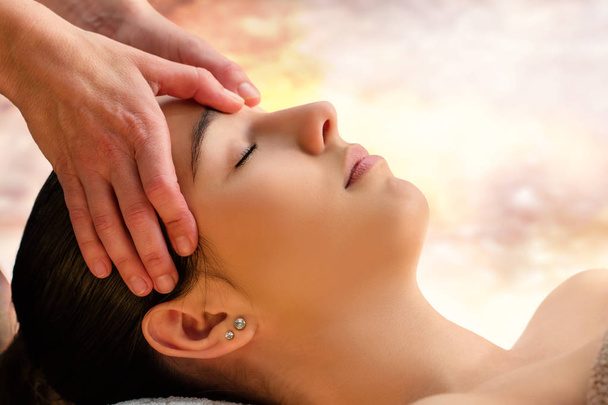 Close up face shot de mulher desfrutando de terapia facial em spa.Therapist massageando a cabeça dianteira com polegares
.  - Foto, Imagem