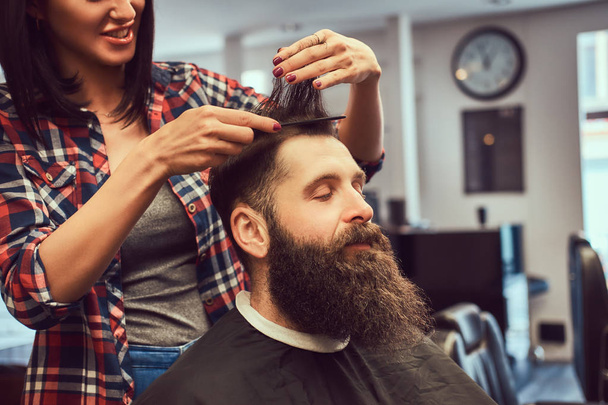 Parrucchiere professionista che fa l'acconciatura con un pettine in un barbiere
.  - Foto, immagini