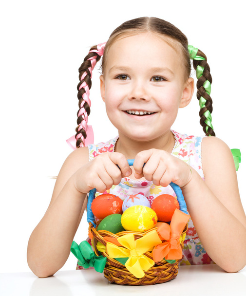 Little girl with basket full of colorful eggs - 写真・画像