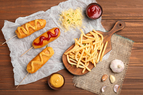 Tasty corn dogs with sauces on table - Fotografie, Obrázek