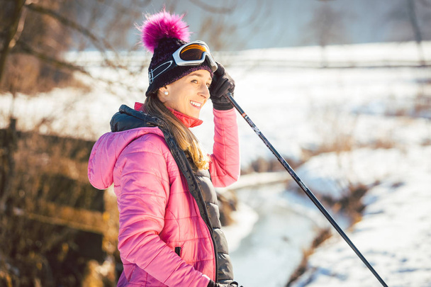 Kobieta na szlak na zimę wędrować w słoneczny krajobraz  - Zdjęcie, obraz