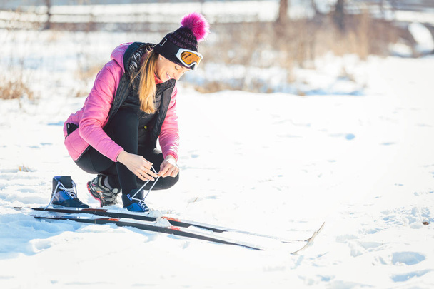 Mulher esquiador cross country colocando no esqui na encosta
  - Foto, Imagem