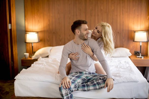 Couple aimant et étreint sur le lit dans la chambre - Photo, image