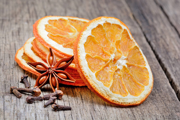 Fruta naranja seca con anís estrellado y clavo de olor en la mesa
 - Foto, imagen