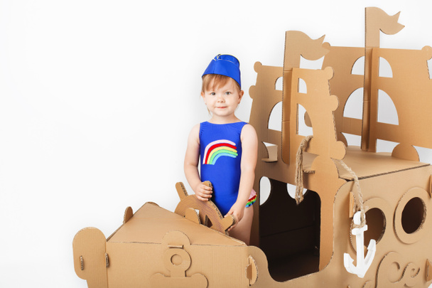 Játszó karton világos fürdőruha viselése aranyos kislány  - Fotó, kép
