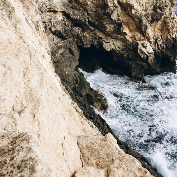 näkymä kallioisille vuorille meressä tummalla vedellä tuulisena päivänä
 - Valokuva, kuva