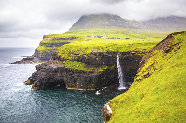 Dramatic waterfall on Faroe Islands and the village Gasadalur - Foto, Bild