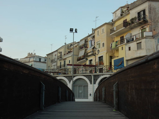 Diamante, Cosenza, Calábria, Itália - 23 de agosto de 2017: A cidade velha vista da ponte pedonal de madeira no início da manhã
. - Foto, Imagem