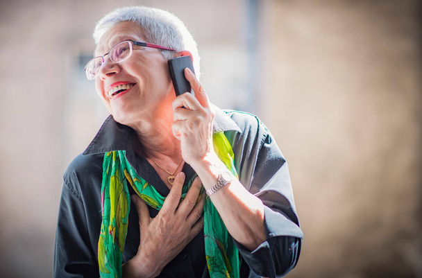 Senior woman having a lovely phone talk - Фото, изображение