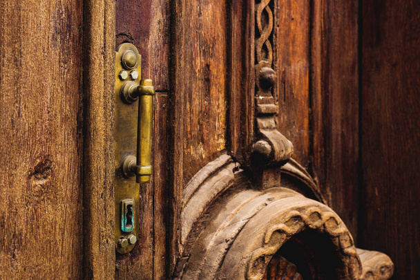 Tło Vintage. Wykonane z mosiądzu stary uchwyt z elementami rzeźbione drzwi drewniane ozdobione masywne drewniane symulujące tkania. Stara koncepcja, antyki stare. Lakierowane starego mahoniu - Zdjęcie, obraz