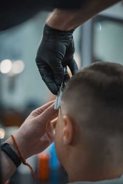 Ideal shape of the beards and haircuts in barbershop. Barber suggests the outline with a razor. Men's body care. Soft focus. - Photo, image