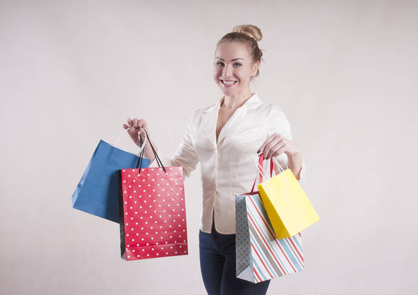 žena s bundou s balíčky pro nákupy studio - Fotografie, Obrázek